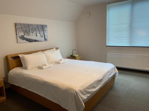 - une chambre avec un lit doté de draps blancs et une fenêtre dans l'établissement Momiji Montana, à Furano