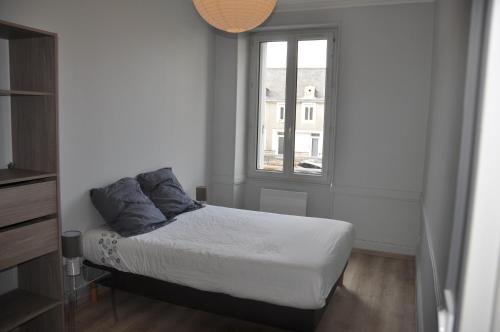 een kleine slaapkamer met een bed en een raam bij agréable duplex Candé centre ville 4/6 places in Candé