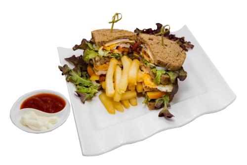 a sandwich and french fries on a plate with ketchup at New Siam Palace Ville Hotel in Bangkok