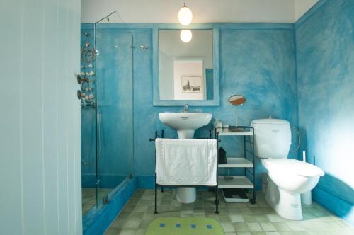 a blue bathroom with a sink and a toilet at Aloizianika 1768 Traditional GuestHouse in Aloïziánika