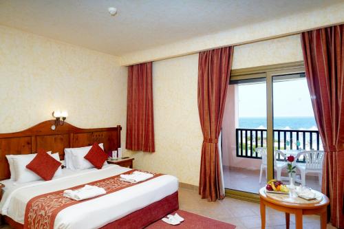 a hotel room with two beds and a balcony at Charmillion Sea Life Resort in Sharm El Sheikh