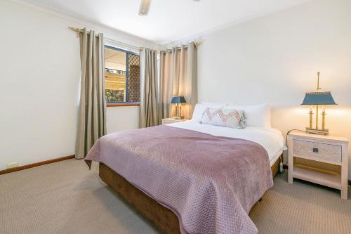 Layman Park Villa في بيرث: غرفة نوم بسرير كبير ونافذة