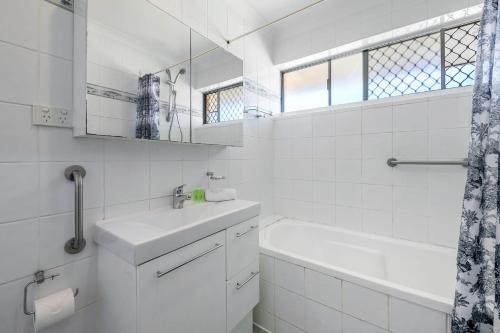 Baño blanco con lavabo y espejo en Layman Park Villa en Perth