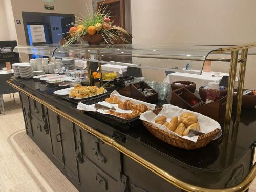 un buffet con varios tipos de pan y bollería en Hotel Sant Agustí, en Barcelona