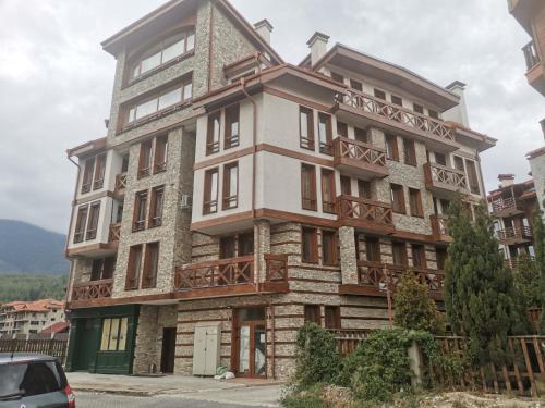 a large apartment building with a car parked in front of it at Studio in Murphys Lodge in Bansko