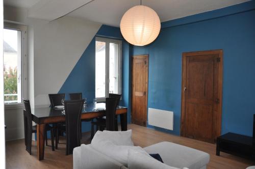 een eetkamer met een tafel en een blauwe muur bij agréable duplex Candé centre ville 4/6 places in Candé
