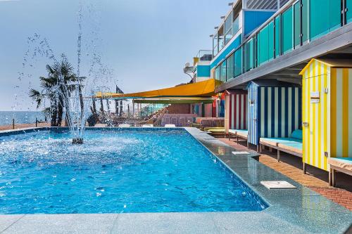 a swimming pool with a fountain in front of a building at UnderSun Spa Hotel in Gribovka