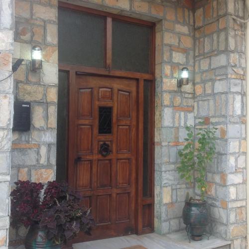 a wooden door on a stone building with a plant at FILIPPOS-Spectacular area,,,,panoramic,-sea- view- apartments-42m, just call on the photo number, for price,vacancy etc,,-next to Vallis hotel,, 15meters from seaside!!! in Agria