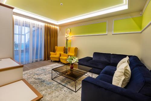 a living room with a blue couch and a yellow chair at UnderSun Spa Hotel in Gribovka