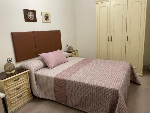 ルーゴにあるCALLE HUERTAS Nº 17 - 1ºのベッドルーム1室(ピンクの枕が付いたベッド1台付)