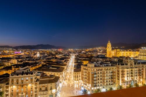 a view of a city at night at Soho Boutique Equitativa in Málaga