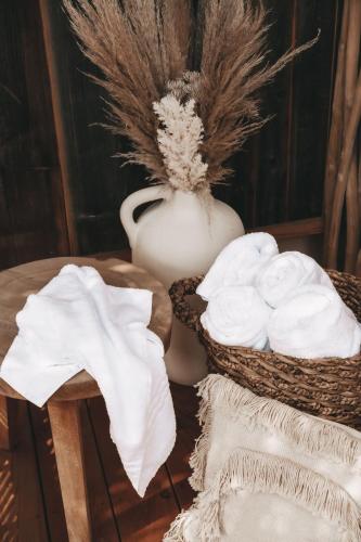 a table with a vase and two baskets of towels at Jufenalm BOHO & Wellnesshotel in Maria Alm am Steinernen Meer