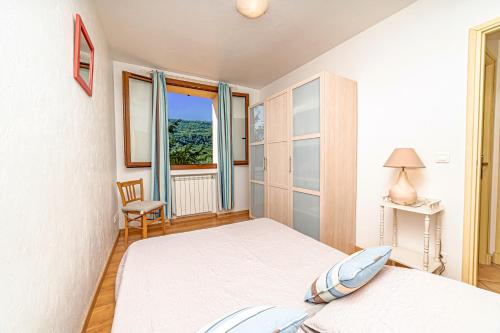 Habitación blanca con cama y ventana en Holidays In Provence Alpes Maritimes, en Le Bar-sur-Loup