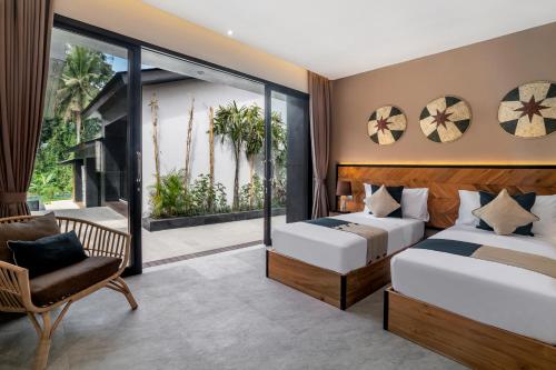 ein Schlafzimmer mit zwei Betten und einem Balkon in der Unterkunft Villa Singa by BaliSuperHost in Ubud