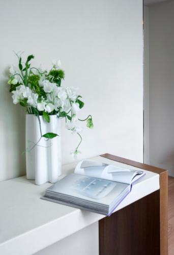 a table with a book and a vase of flowers at Hotel Max in Paris
