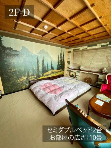 a bed in a room with a painting on the wall at 華明の宿 in Ebetsu
