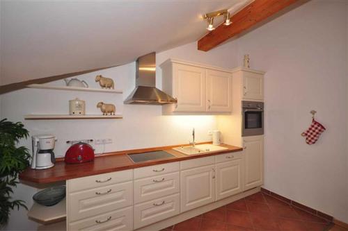 een keuken met witte kasten en een wastafel bij Residenz an der Prorer Wiek Ferienwohnung 12 in Binz