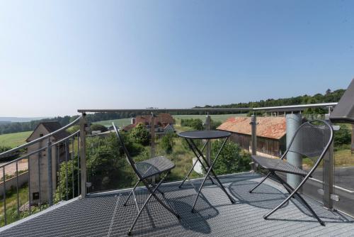 a patio with two chairs and a table on a balcony at Villa Geisenhof in Miltenberg