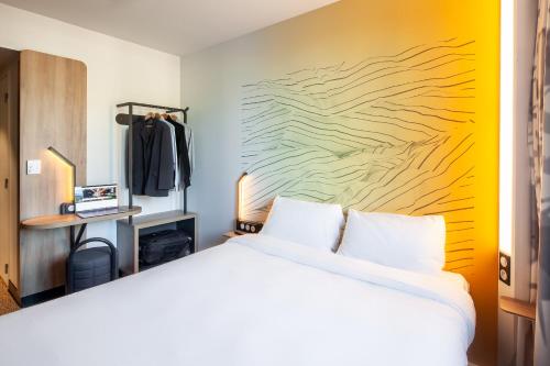 a bedroom with a white bed and a yellow wall at B&B HOTEL Bois d'Arcy Saint Quentin en Yvelines in Bois-dʼArcy