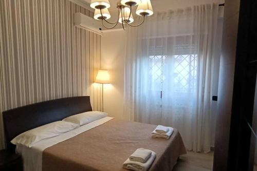 a bedroom with a bed with a chandelier and a window at Appartamento di Zeno in Rome