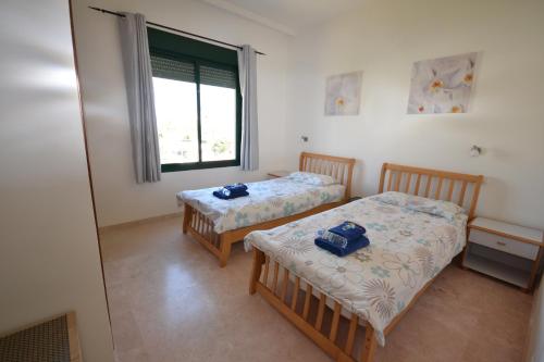 Duas camas num quarto com uma janela em Almadraba 323 em Manilva