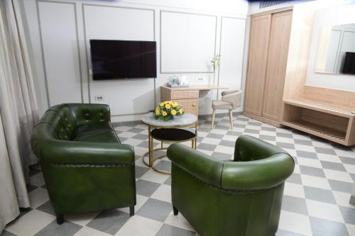 a living room with two green chairs and a table at Fortune Valley View, Manipal - Member ITC Hotels' Group in Manipala