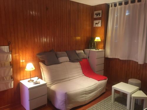 1 dormitorio con 1 cama, 2 mesas y 2 lámparas en Studio cabine 3 couchages près des pistes en Orcières