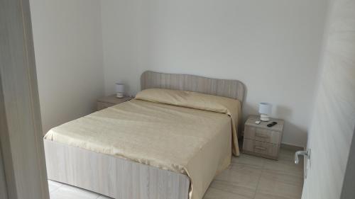 a small bedroom with a bed and a night stand at Alfiere 59 in Reggio di Calabria