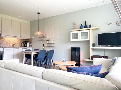a living room with a white couch and a kitchen at Vakantieappartement Westkapelle WE06 in Westkapelle