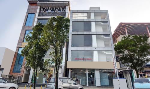 a tall building with cars parked in front of it at Itsy Hotels Shrey'S Inn Mallandur Road in Chikmagalūr