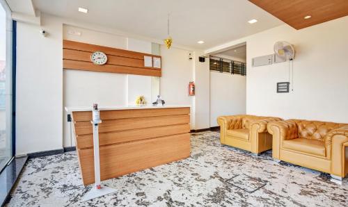 a living room with two couches and a kitchen at Itsy Hotels Shrey'S Inn Mallandur Road in Chikmagalūr