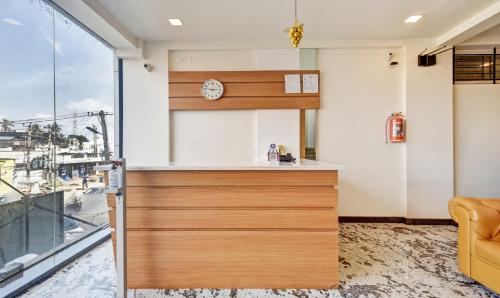 a kitchen with a counter and a clock on the wall at Itsy Hotels Shrey'S Inn Mallandur Road in Chikmagalūr