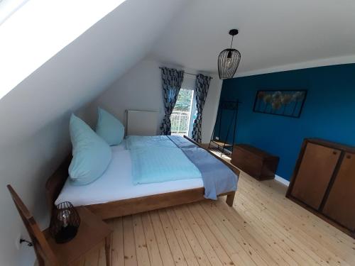 um quarto com uma cama com paredes azuis e uma janela em Ferienhaus Wiesenblick em Monschau