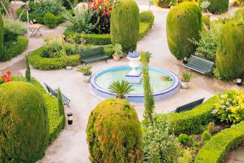a garden with a fountain and many plants and trees at Casa de los Bates in Motril