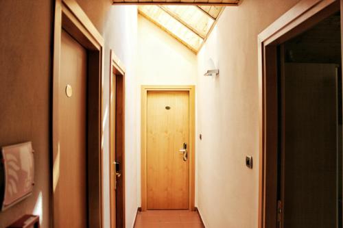 a hallway with a wooden door and a window at Albergo Hofer in Bolzano