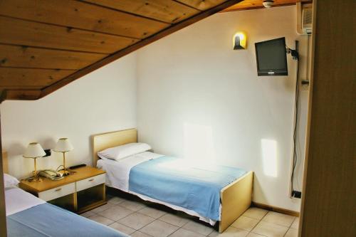 pokój hotelowy z dwoma łóżkami i telewizorem w obiekcie Albergo Hofer w mieście Bolzano