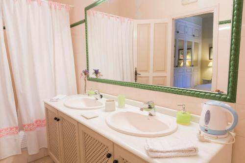 a bathroom with two sinks and a large mirror at Casa de los Bates in Motril