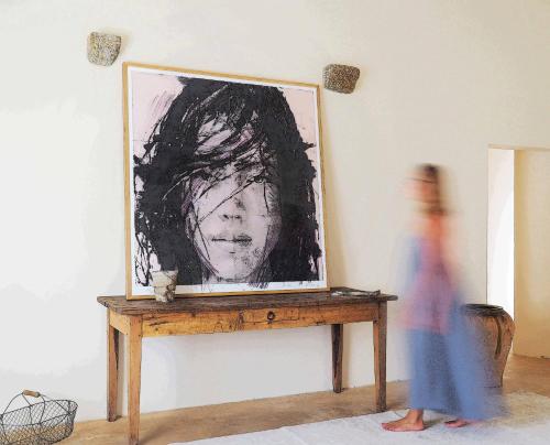 a person walking in front of a painting on a table at Mas Rauric in Llagostera