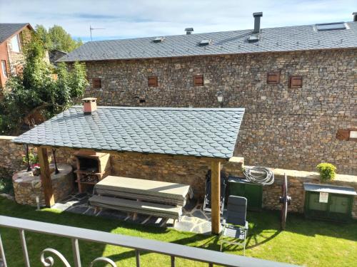 an outdoor kitchen with a roof on a building at Cal Teler-Benedicta in Olopte