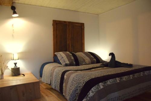 Un dormitorio con una cama con un pájaro negro. en Gîte Terra Bosca, en Cambounès