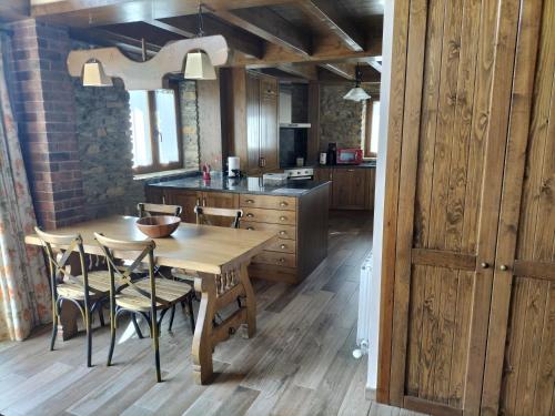 a kitchen with a wooden table and chairs at Cal Teler-Benedicta in Olopte