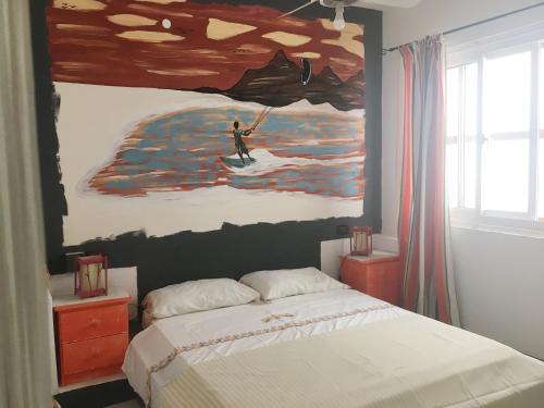 Ca Greta Deluxe في سال ري: غرفة نوم مع لوحة لرجل على لوح ركوب الأمواج
