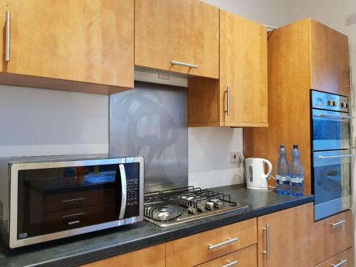uma cozinha com um micro-ondas e um fogão forno superior em Sheffield City Suites em Manor