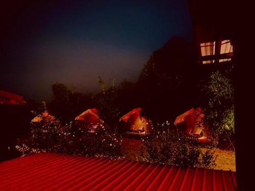 a group of tents with red roofs at night at Samskara & Samsara in Lansdowne