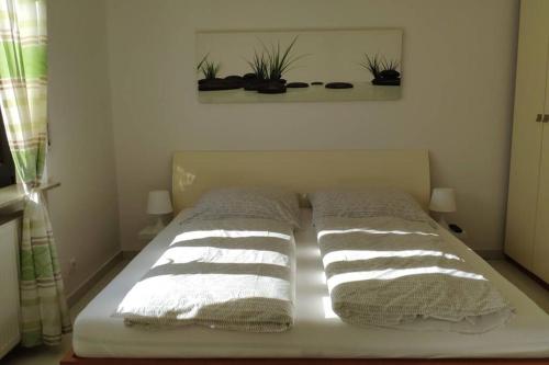 a bed with three pillows on it in a room at Schöne Wohnung in ruhiger zentraler Lage in Rodgau