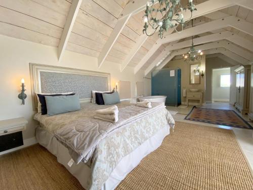 a large bedroom with a large bed with a chandelier at Induku in Paternoster
