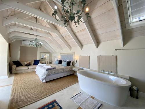 a large bathroom with a tub and a living room at Induku in Paternoster