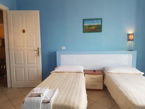 1 dormitorio con 2 camas y pared azul en Hotel The Marins en Bra