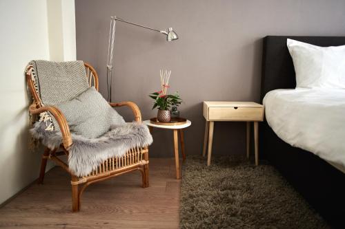 a bedroom with a bed and a chair and a table at B&B La Festa in Amsterdam