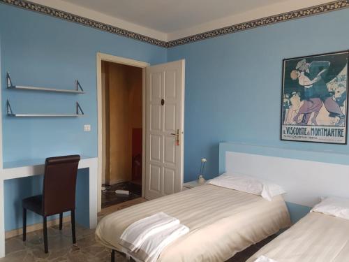a blue bedroom with two beds and a chair at Hotel The Marins in Bra